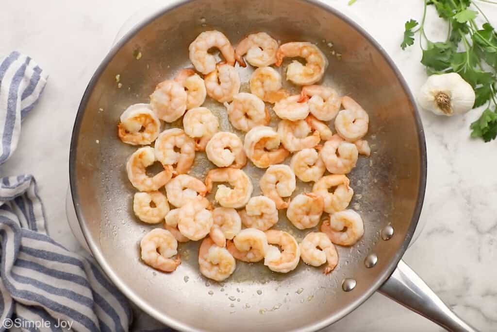 Overhead of skillet of shrimp to make shrimp Alfredo recipe
