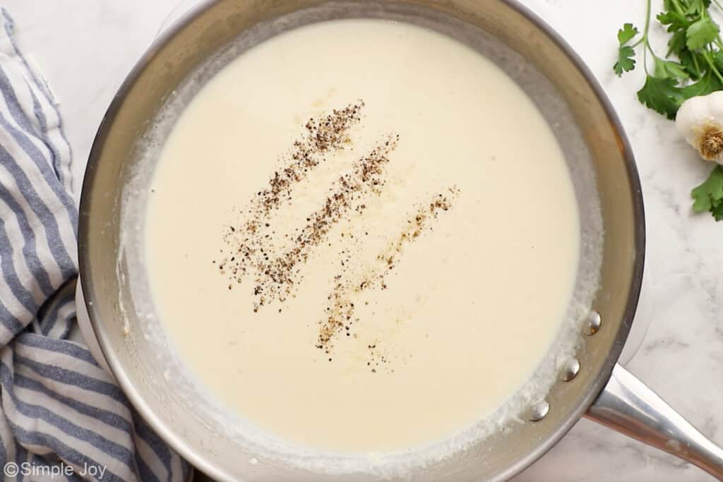 Overhead of skillet of Alfredo sauce ingredients to make shrimp Alfredo