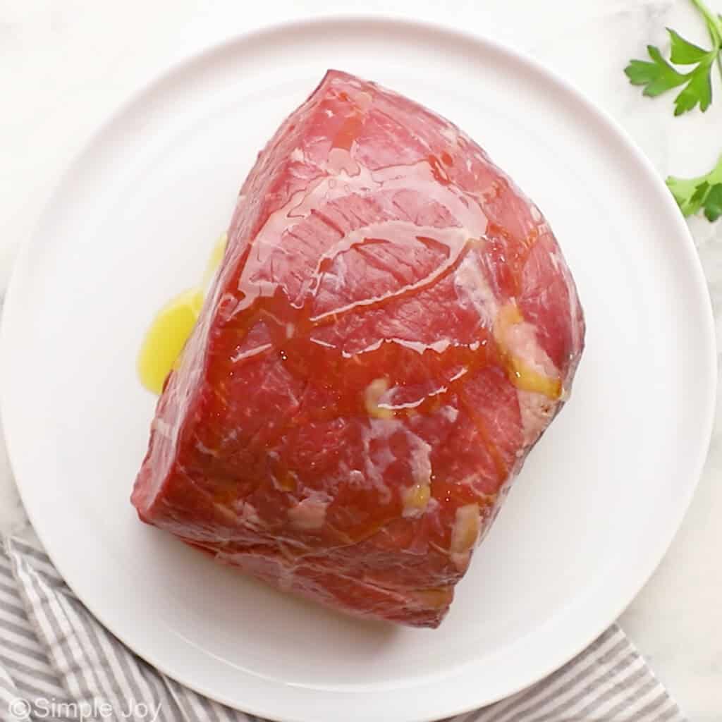 Overhead of sirloin tip roast with oil on a plate
