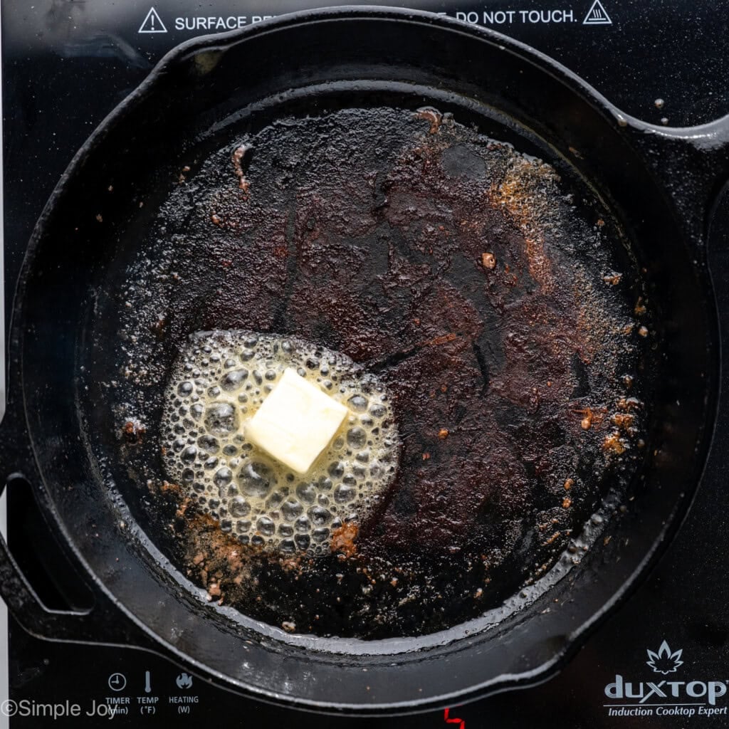 Overhead of skillet with butter melting to make Garlic Butter Steak Bites recipe