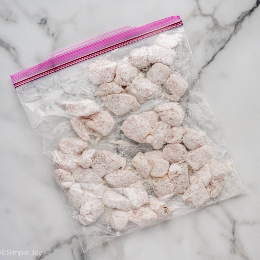 ziplock bag of chicken coated in flour to make Sweet and Sour Chicken recipe