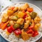plate of white rice topped with Sweet and Sour Chicken