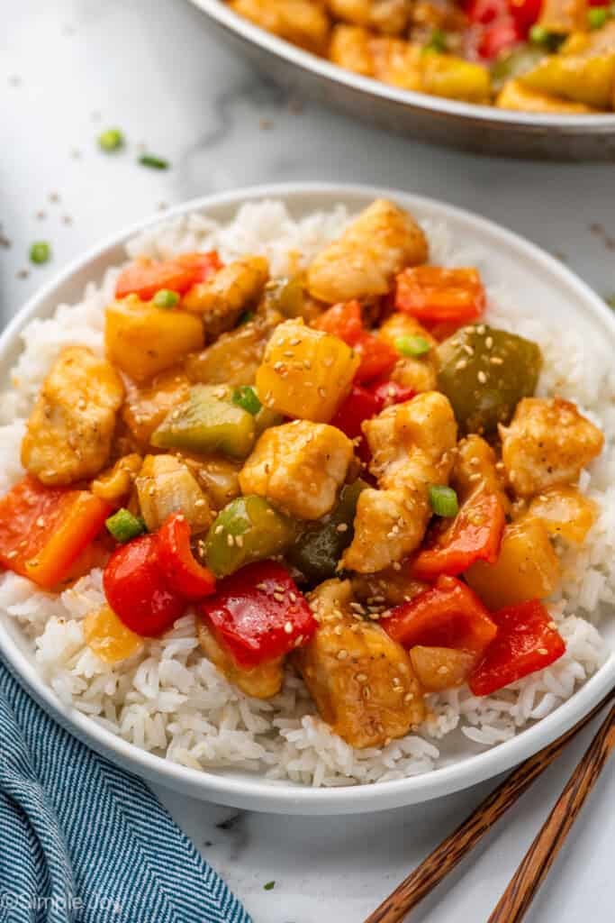 plate of white rice topped with Sweet and Sour Chicken