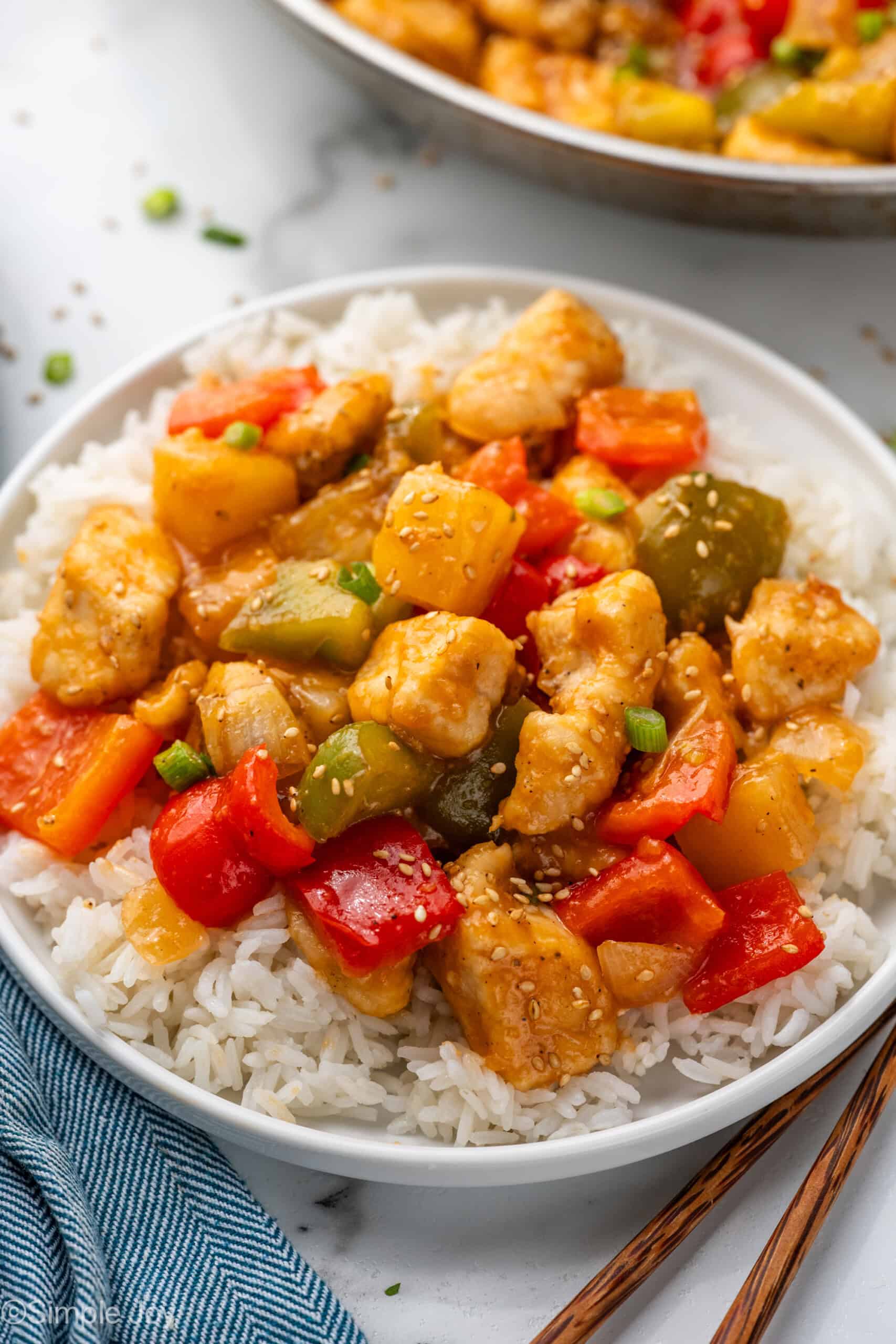 plate of white rice topped with Sweet and Sour Chicken