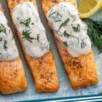 Pinterest graphic for Broiled Salmon with Lemon Dill Sauce. Time shows close up of Broiled Salmon topped with Lemon Dill Sauce, garnished with lemon slices and fresh dill. Says "broiled salmon simplejoy.com"