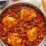 Pinterest graphic for Chicken Cacciatore. Says "The Best Chicken Cacciatore simplejoy.com" Image shows overhead of skillet of Chicken Cacciatore with baguette slices and tongs sitting beside.
