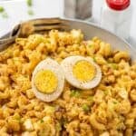 Pinterest graphic for Deviled Egg Pasta Salad. Says "Deviled Egg Pasta Salad recipe" Image shows a bowl of Deviled Egg Pasta Salad garnished with a hardboiled egg and paprika.