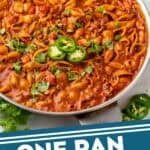 Pinterest graphic for One Pan Cheesy Taco Pasta. Image shows a skillet of One Pan Cheesy Taco Pasta garnished with cilantro and sliced jalapeƱo. Says "One Pan Cheesy Taco Pasta simplejoy.com"