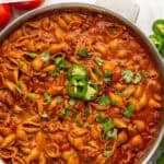 Pinterest graphic for One Pan Cheesy Taco Pasta. Says "One Pot Taco Pasta Recipe simplejoy.com" Image shows overhead of skillet of One Pan Cheesy Taco Pasta garnished with diced jalapeƱo and cilantro