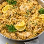 Pinterest graphic for One Pot Lemon Chicken and Orzo. Image shows a skillet of One Pot Lemon Chicken and Orzo garnished with fresh parsley and lemon slices. Says "one pot chicken & orzo simplejoy.com"