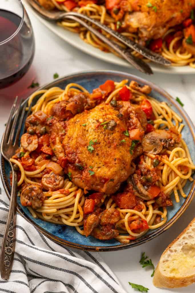 Plate of Chicken Cacciatore with spaghetti and a fork