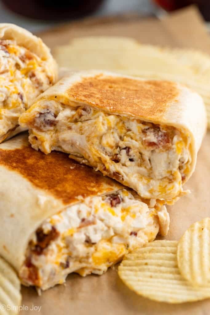 Close up of crack chicken wraps with potato chips sitting beside