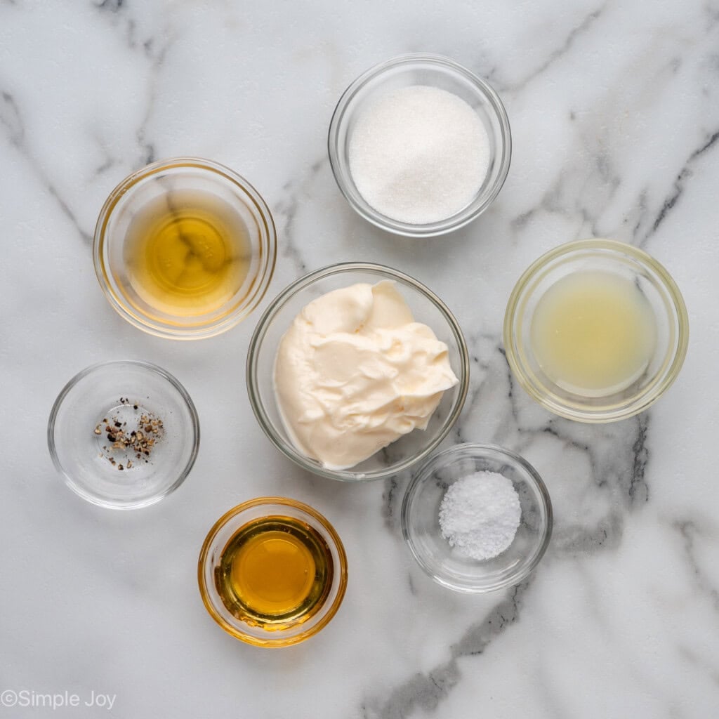Overhead of small glass bowls of apple slaw dressing ingredients