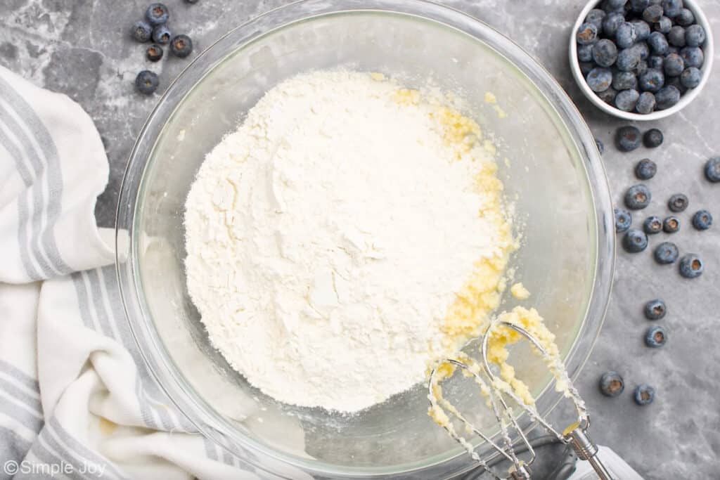 Overhead of glass bowl of blueberry cobbler ingredients