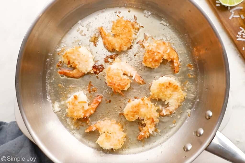 Overhead of skillet of coconut shrimp cooking