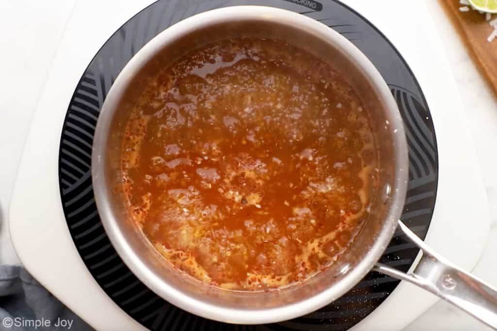 Overhead of saucepan of chili sauce ingredients for coconut shrimp recipe