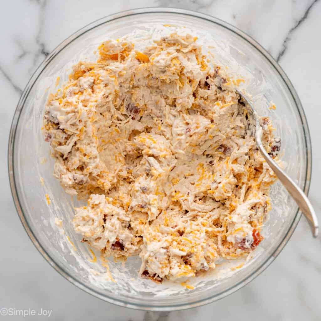 Overhead of bowl of crack chicken wraps ingredients with a fork