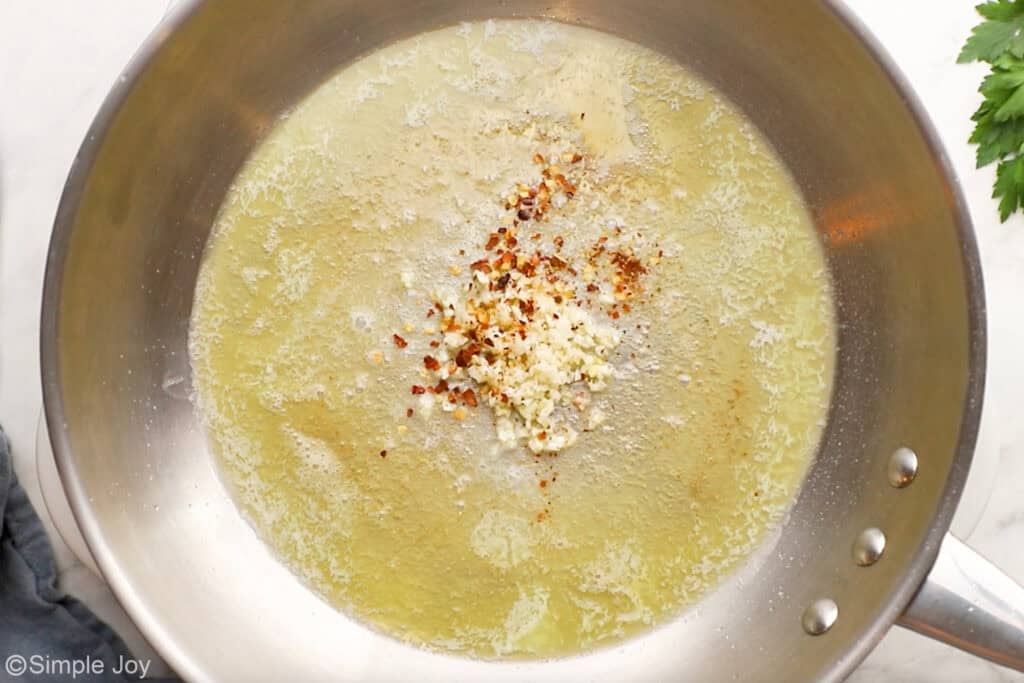 Overhead of skillet of garlic and red pepper flakes in butter to make garlic butter shrimp