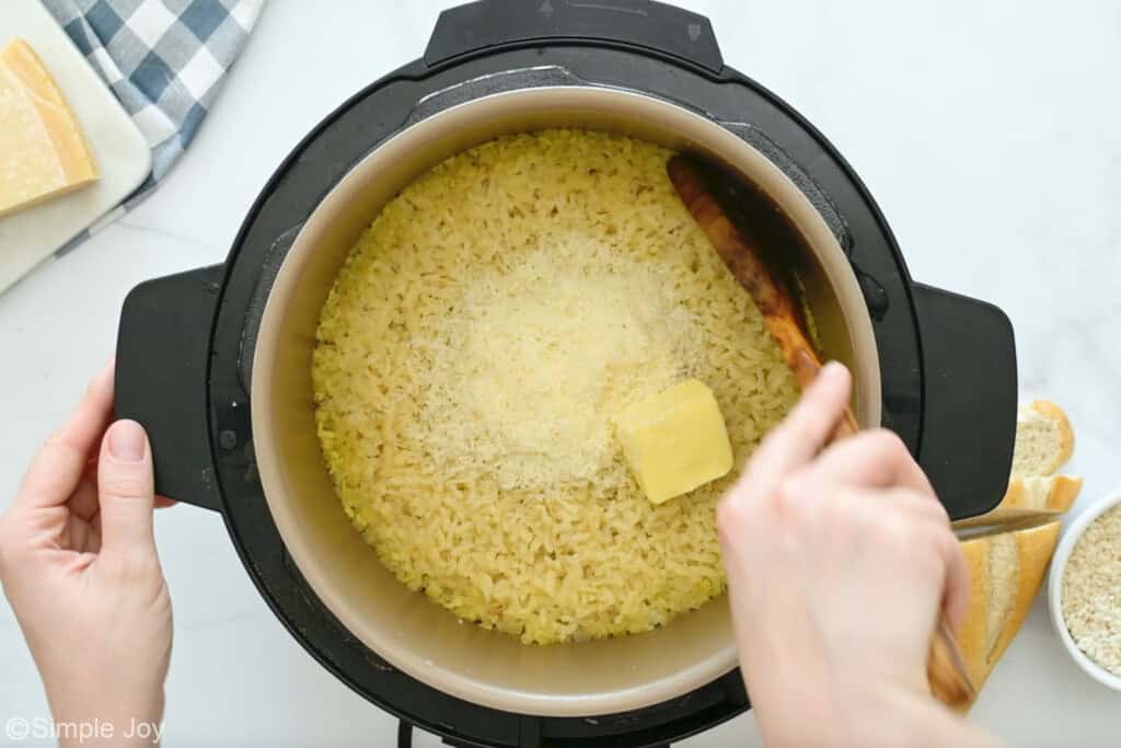 Overhead of person stirring butter and parmesan cheese into Instant Pot Risotto ingredients in instant pot