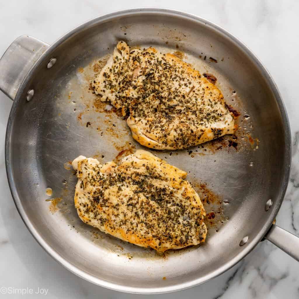 Overhead of chicken cooking in skillet to make One Pot Lemon Chicken and Orzo