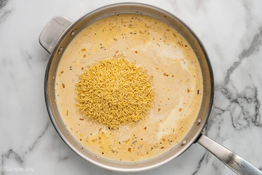 Overhead of skillet of One Pot Lemon Chicken and Orzo ingredients