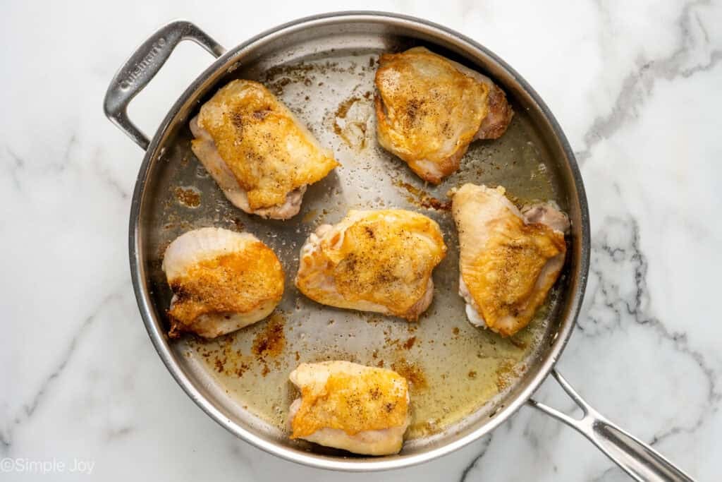 Overhead of skillet of chicken thighs to make One Pot Coconut Lime Chicken