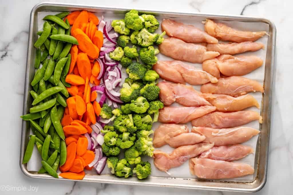 Overhead of Honey Garlic Chicken and Vegetables ingredients on lined baking sheet