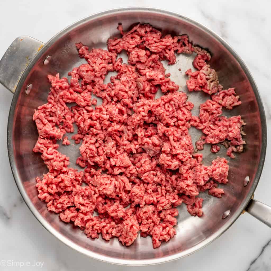 Overhead of skillet of ground beef to make One Pan Cheesy Taco Pasta recipe