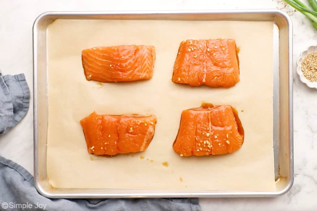 Overhead of teriyaki salmon on a lined baking sheet