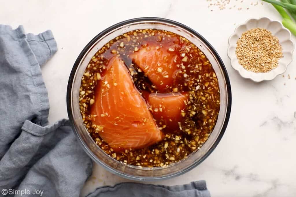 Overhead of glass bowl of teriyaki sauce and salmon to make teriyaki salmon recipe