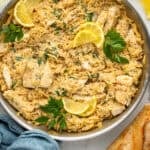 Overhead of skillet of One Pot Lemon Chicken and Orzo garnished with lemon slices and fresh parsley