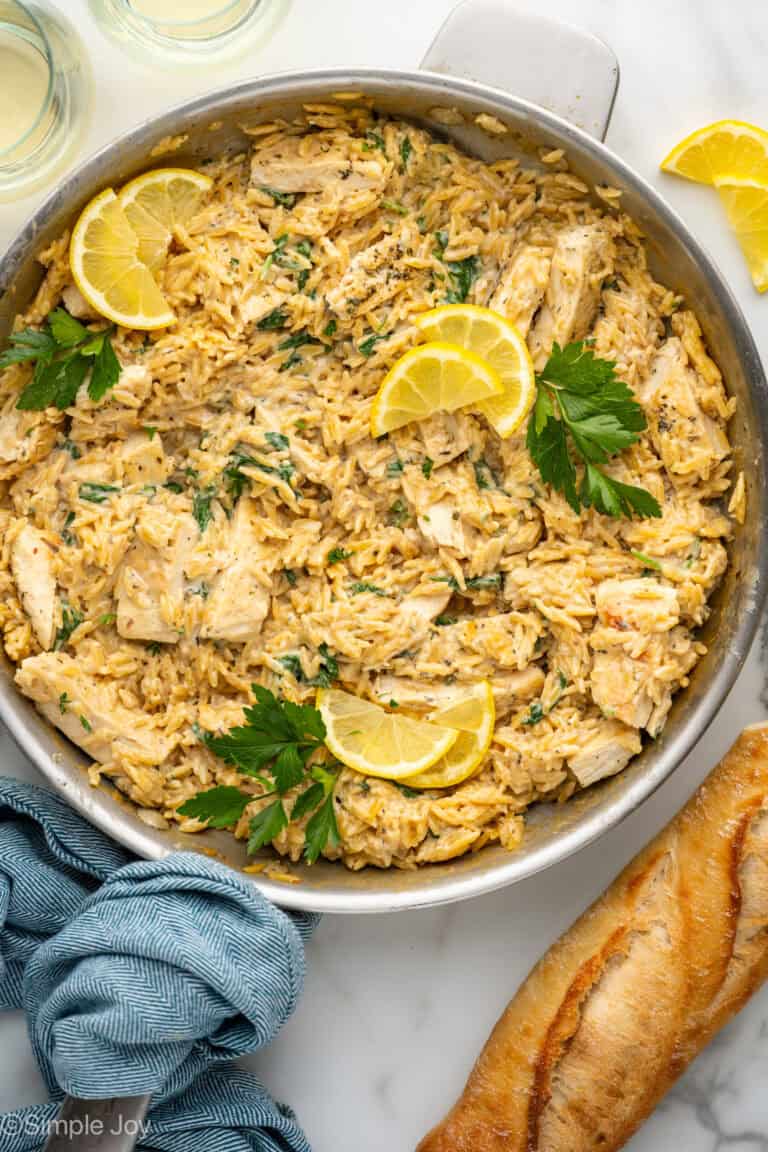 Overhead of skillet of One Pot Lemon Chicken and Orzo garnished with lemon slices and fresh parsley