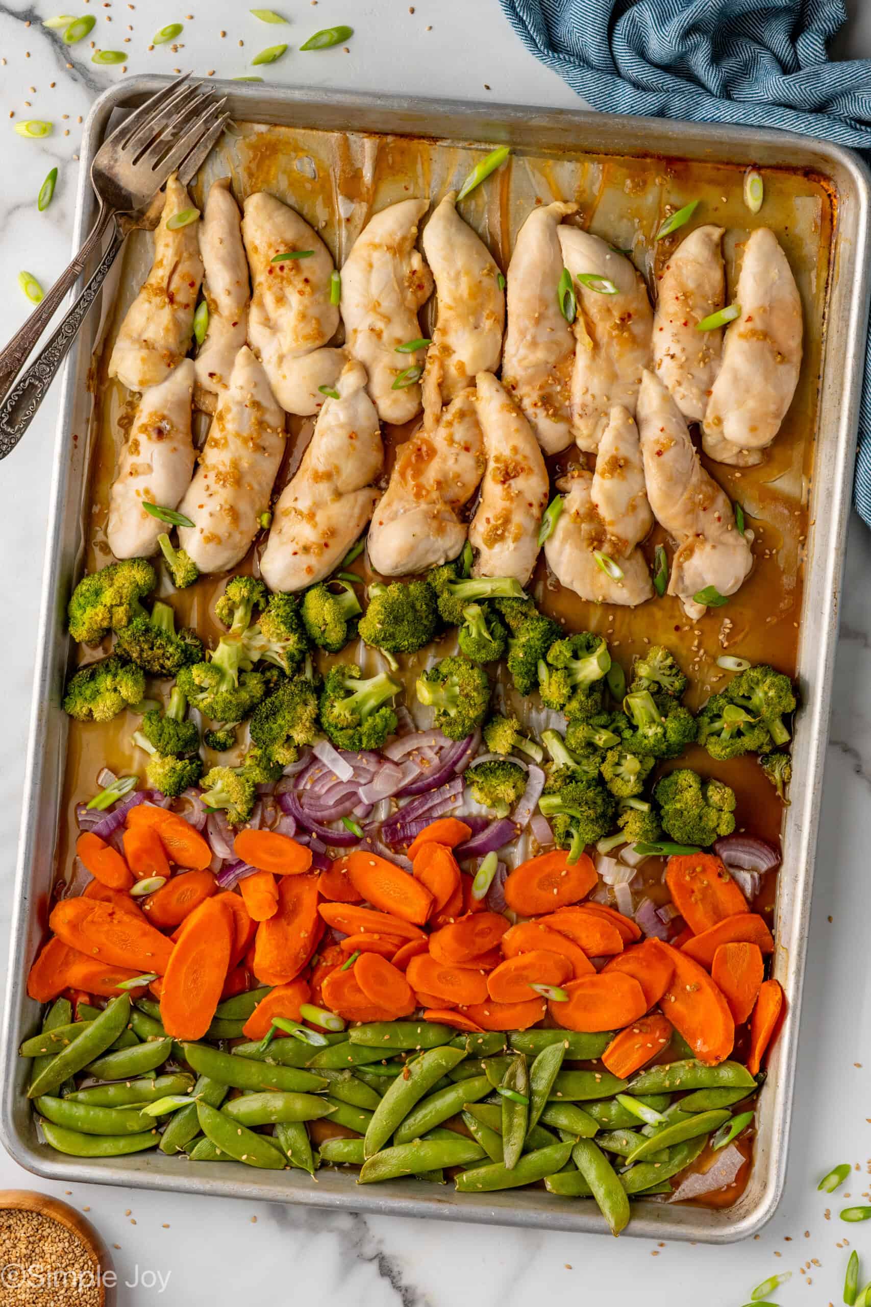 Overhead of sheet pan Honey Garlic Chicken and Vegetables with two forks