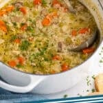 Pinterest graphic for chicken and rice soup. Image shows a large stock pot of chicken and rice soup garnished with fresh parsley with a ladle. Says "chicken & rice soup simplejoy.com"