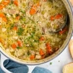 Pinterest graphic for chicken and rice soup. Image shows overhead of large Dutch oven of chicken and rice soup garnished with fresh parsley with a ladle. Says "super easy chicken & rice soup simplejoy.com"