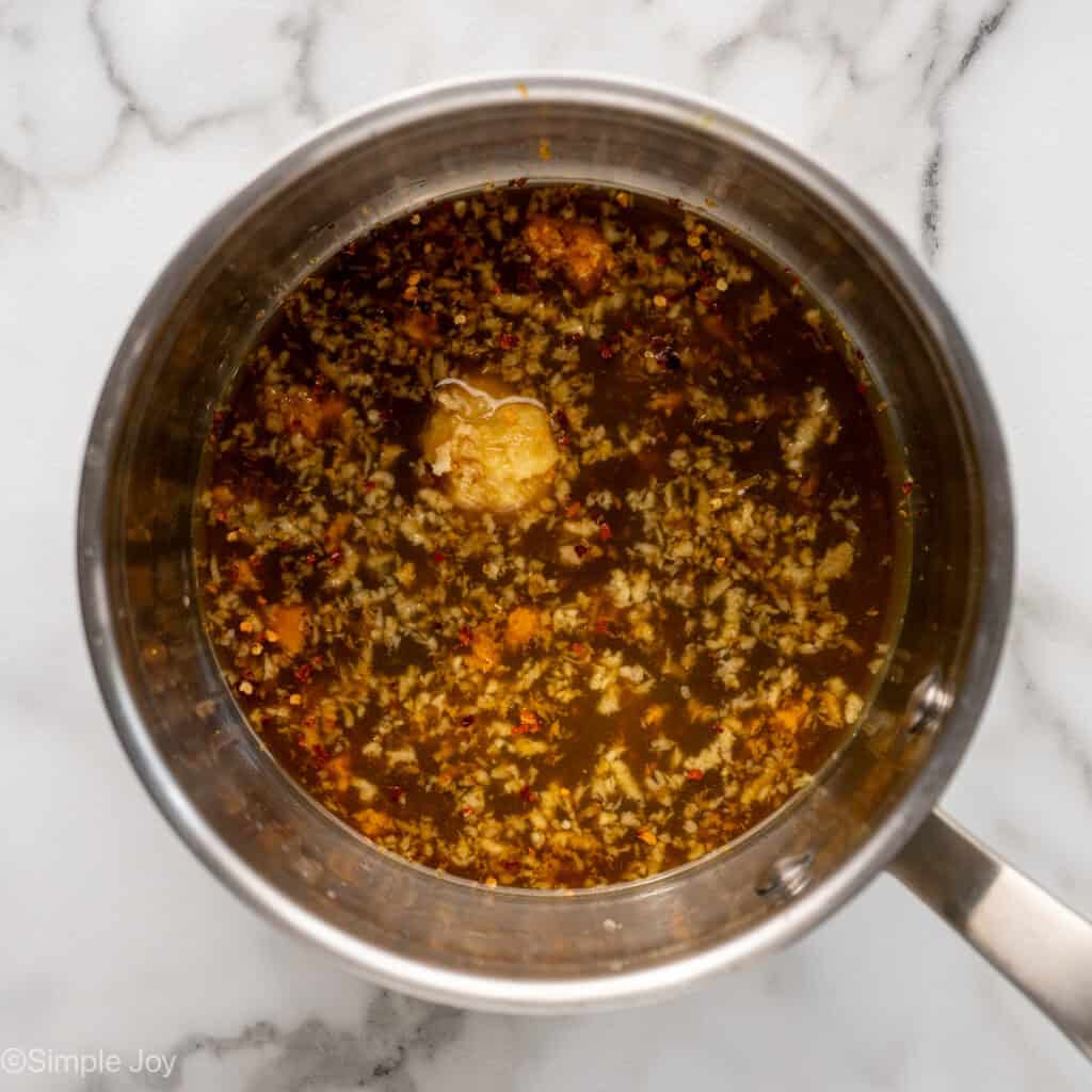 Overhead of saucepan with orange chicken sauce ingredients to make baked orange chicken