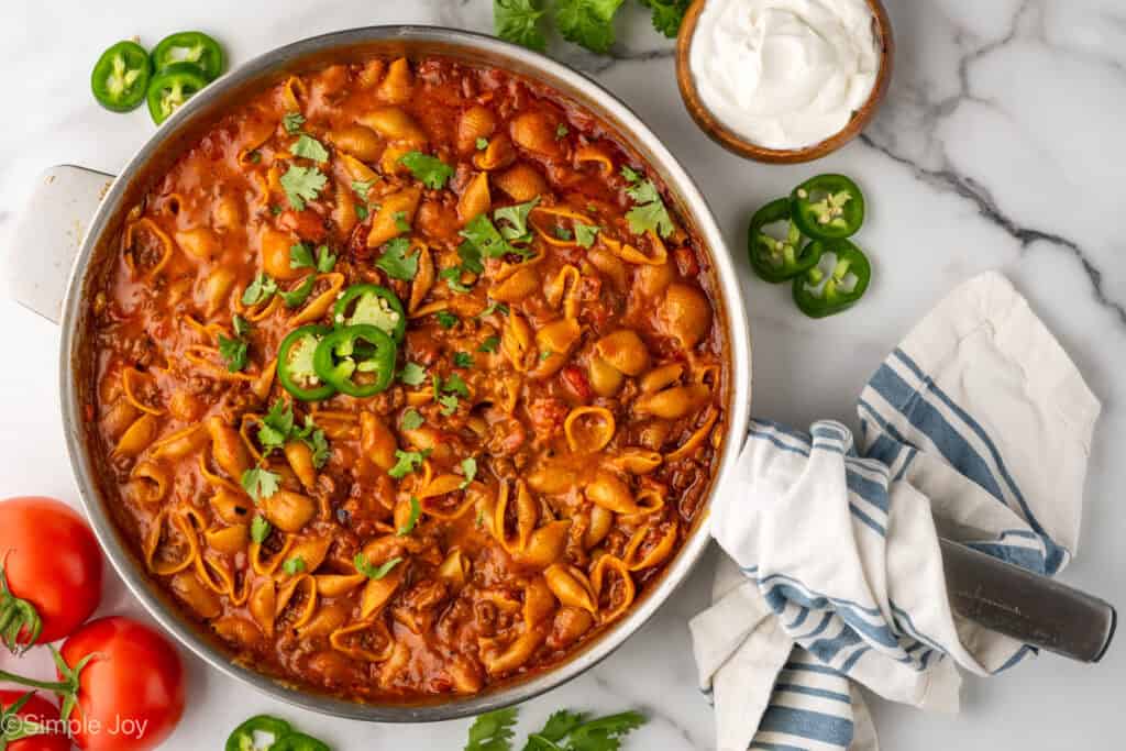 overhead of a skillet of taco pasta garnished with fresh jalapeƱos and cilantro