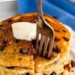 Pinterest graphic for chocolate chip pancakes. Says "chocolate chip pancake recipe simplejoy.com" Image shows a stack of chocolate chip pancakes on a plate topped with butter and a fork