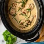 Pinterest graphic for Crockpot Marry Me Chicken. Image shows overhead of slow cooker of marry me chicken garnished with fresh basil. Says "slow cooker marry me chicken simplejoy.com"