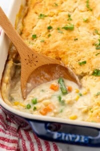 Wooden spoon in casserole dish of chicken cobber