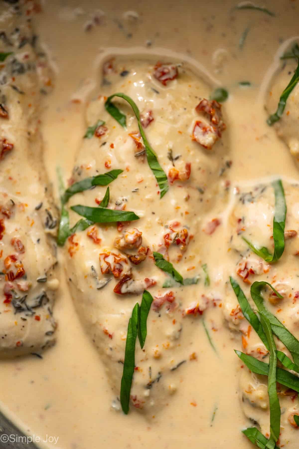 Overhead of Crockpot Marry Me Chicken garnished with fresh basil leaves