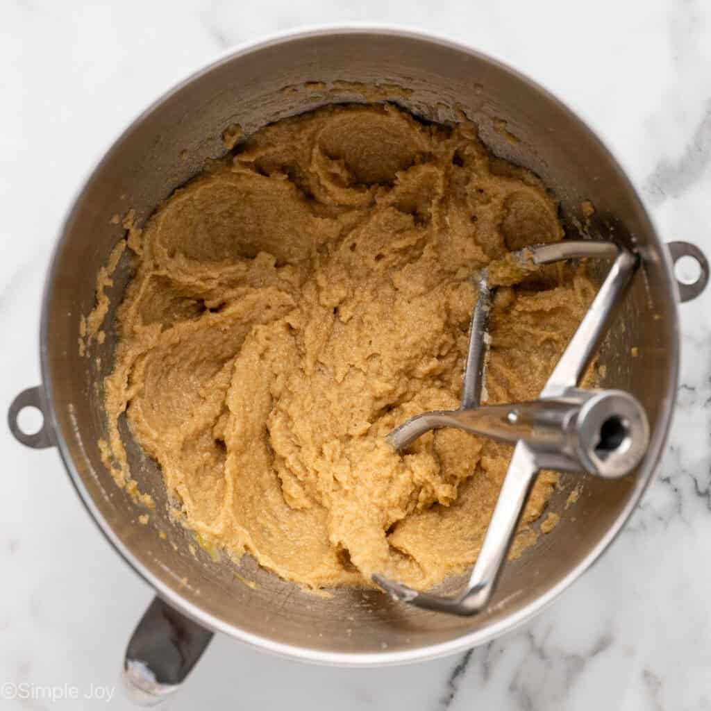 Overhead of apple cookie ingredients in a mixing bowl with paddle attachment