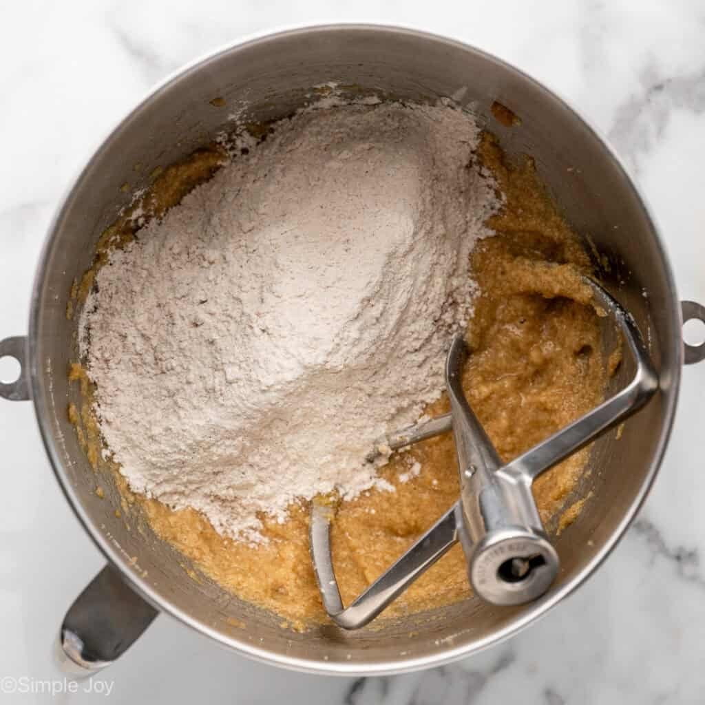 Overhead of apple cookie ingredients in a mixing bowl with paddle attachment