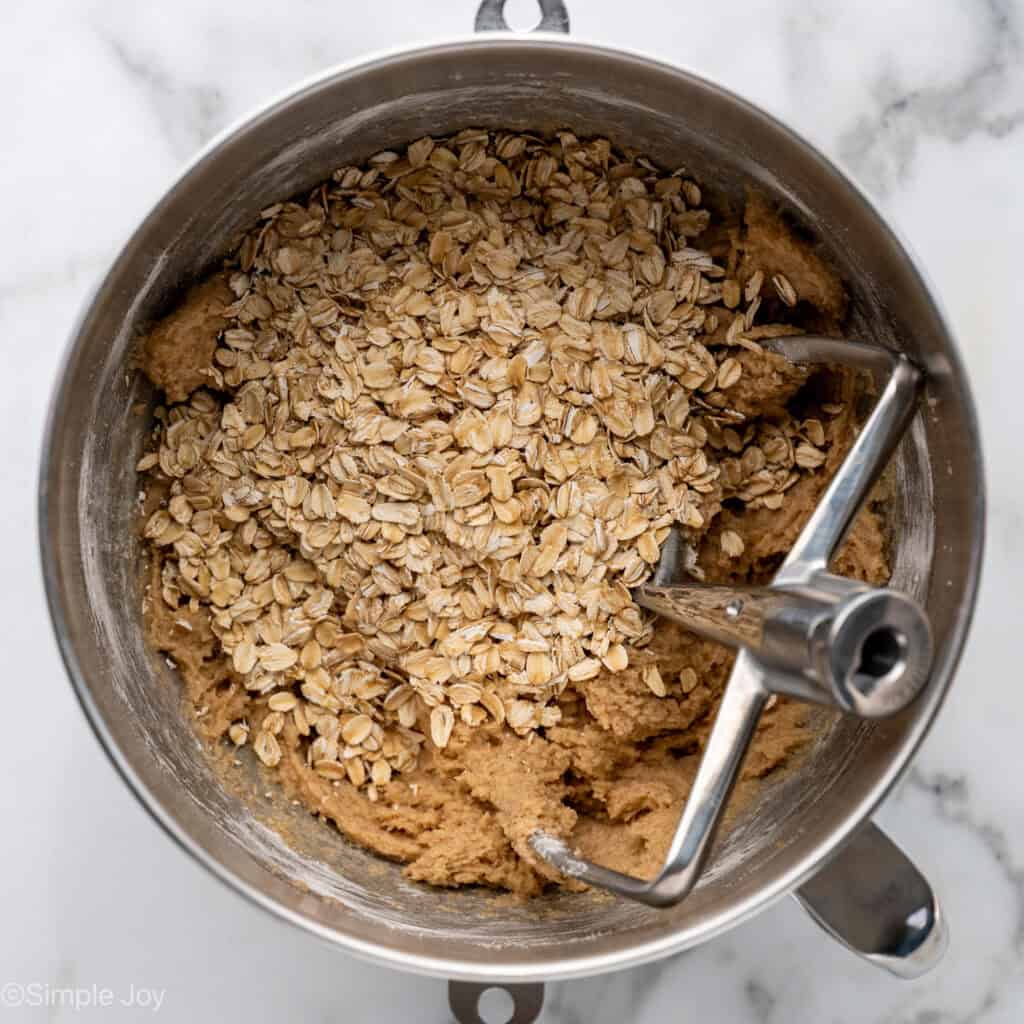 Overhead of apple cookie ingredients in a mixing bowl with paddle attachment
