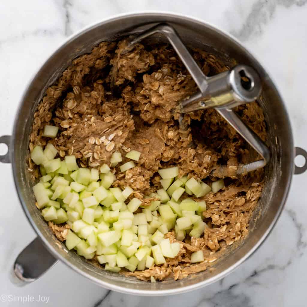 Overhead of apple cookie ingredients in a mixing bowl with paddle attachment