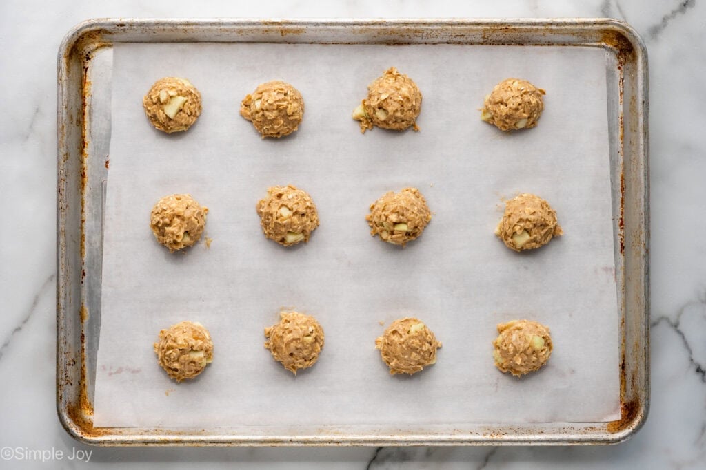 Overhead of apple cookie dough balls on a parchment lined baking sheet