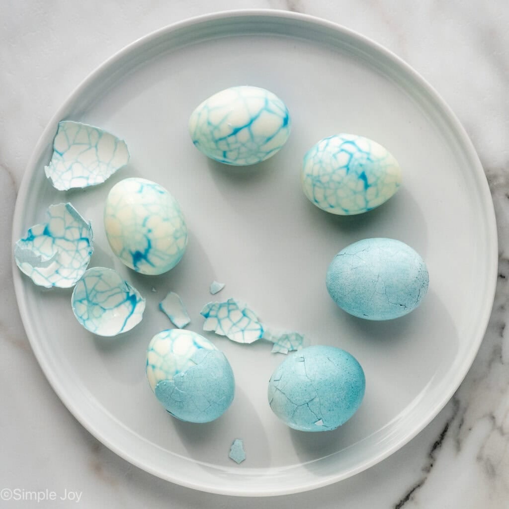 Overhead of hard boiled eggs and shells on a plate to make Halloween Deviled Eggs recipe