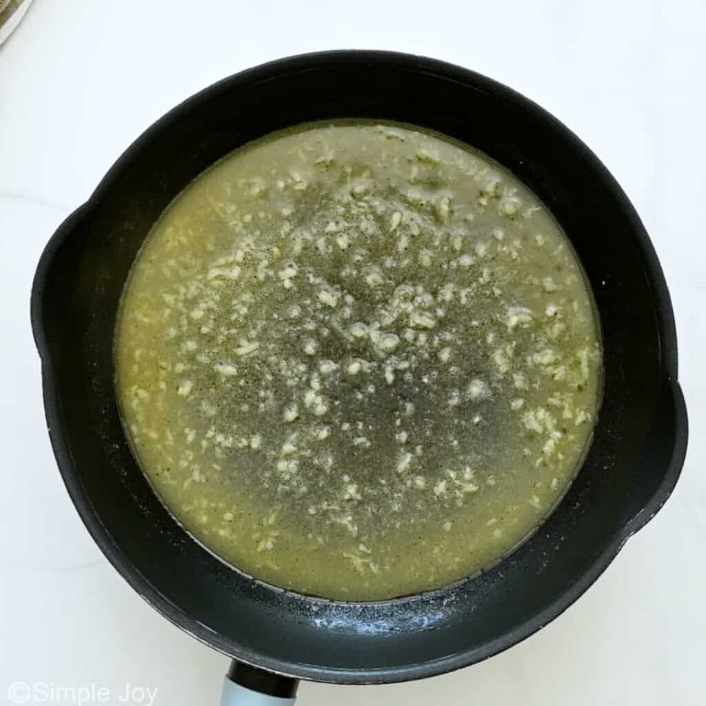 Overhead of skillet of butter and garlic to make ham and pea pasta recipe