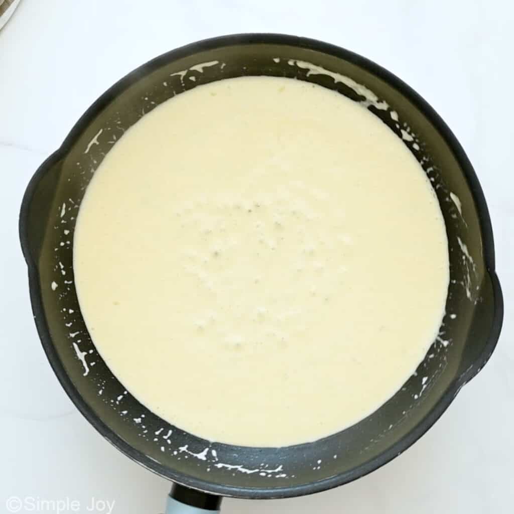 Overhead of skillet of ham and pea pasta ingredients