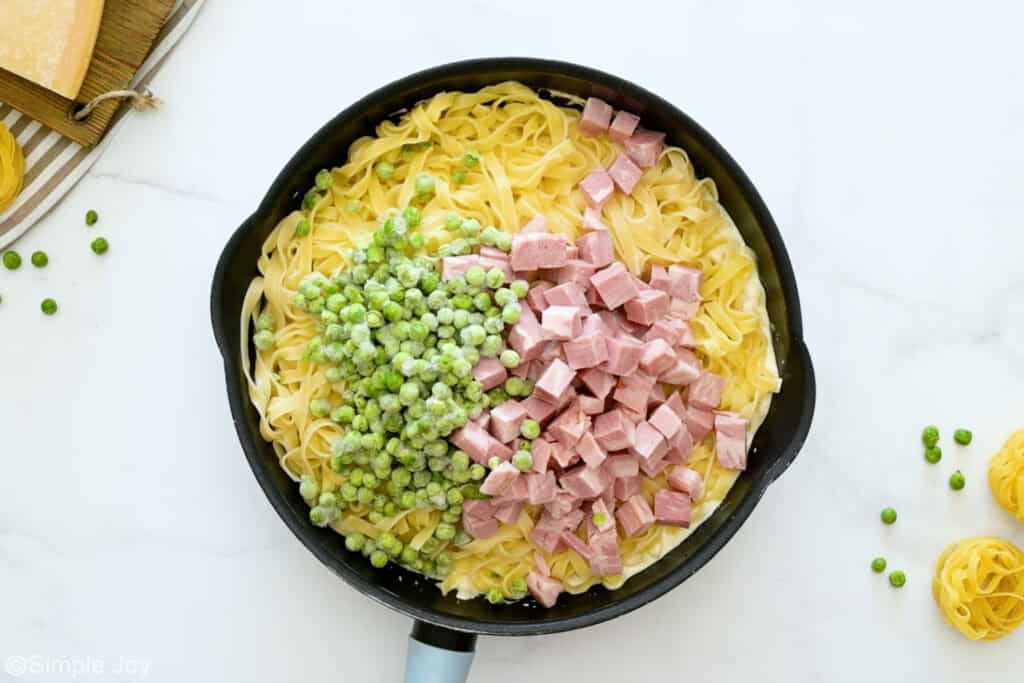 Overhead of skillet of ham and pea pasta ingredients